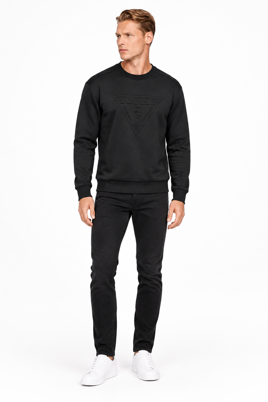 Modello a figura intera con felpa nera, jeans neri e sneakers bianche