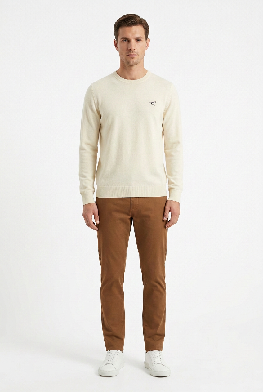 Modello con maglione chiaro senza bordo a contrasto e chinos marroni