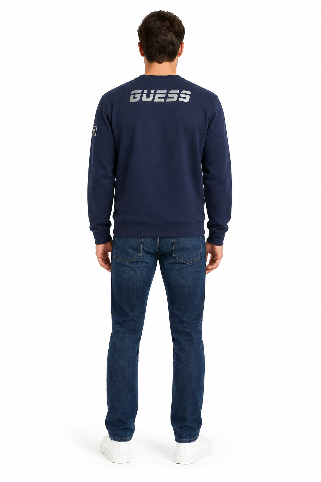 Modello visto da dietro con felpa Guess navy e logo argentato